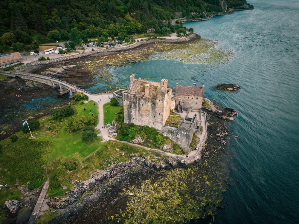 an aerial view of a castle in the middle of a body of water