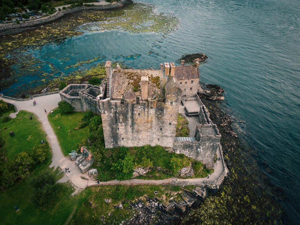 an aerial view of a castle in the middle of a body of water