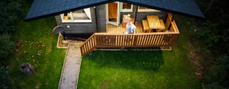 a person standing on a deck in front of a house