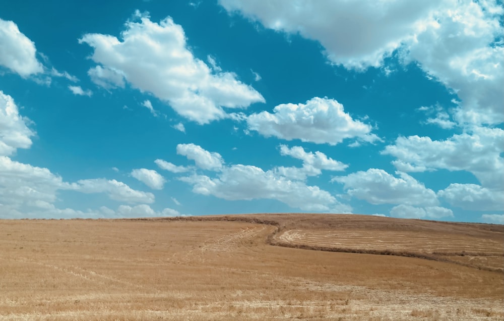 a field with a few clouds in the sky