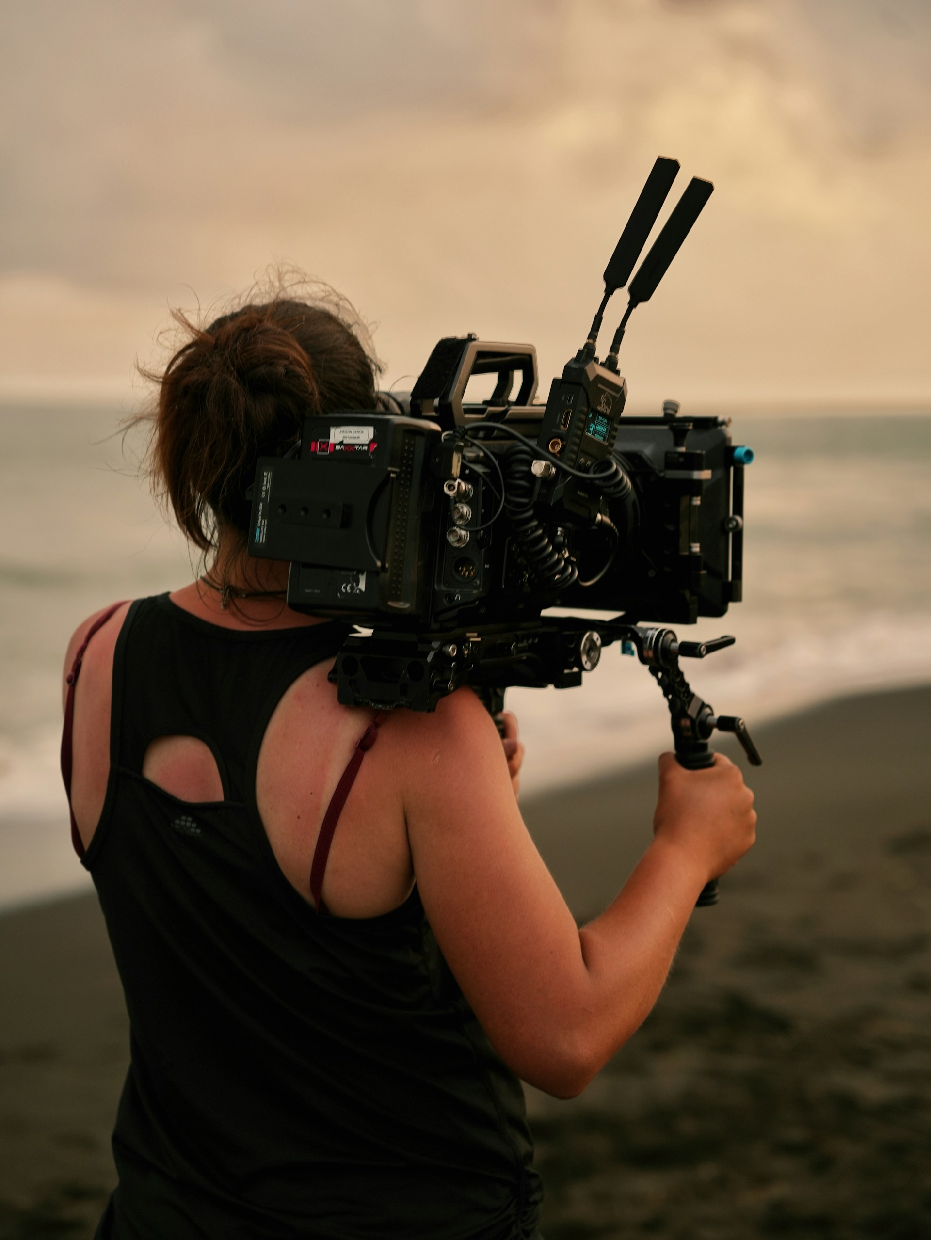 a woman with a camera on a beach