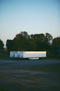 A Frostline Mobile Refrigeration trailer parked outside a bustling Los Angeles event venue at sunset.