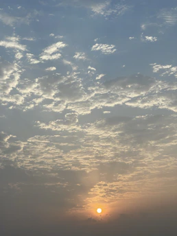 A serene sunrise breaking through soft clouds, symbolizing hope and new beginnings.