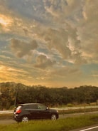 A vigilant security guard monitoring a convoy on a highway at dusk