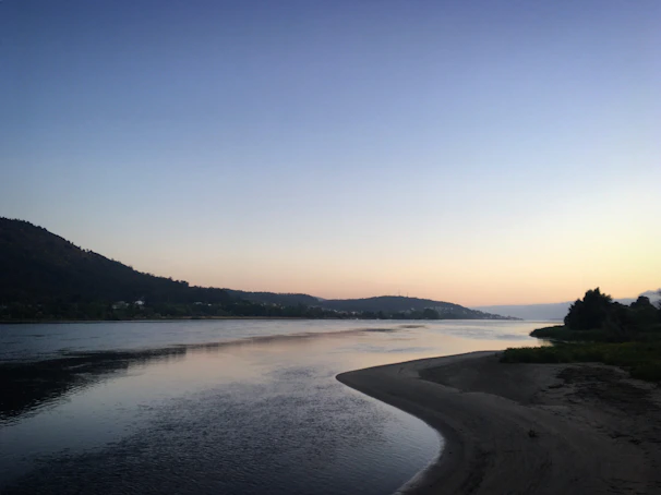 The serene Ganga river flowing gently beside the ashram at dawn.