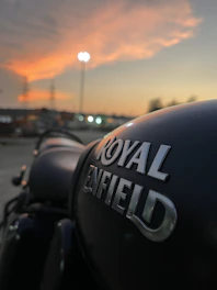 A sleek Royal Enfield motorcycle parked against a sunset backdrop, embodying freedom and adventure.