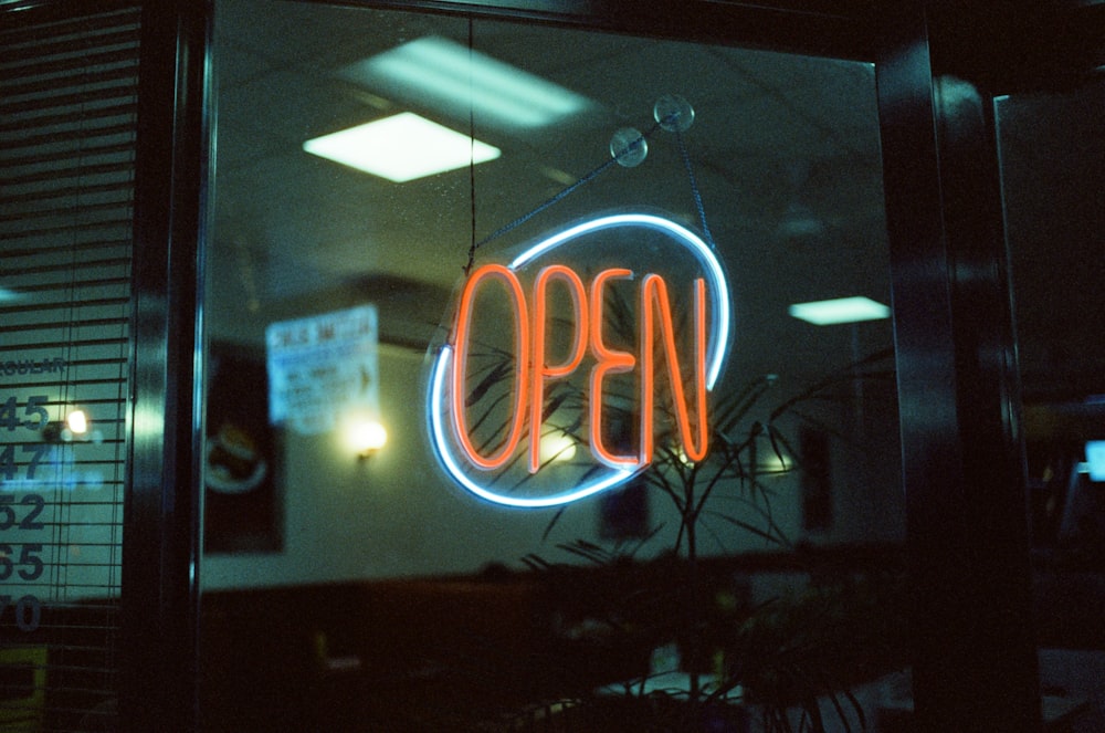 a neon sign that reads open in a window