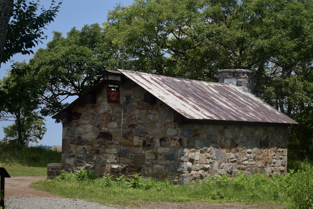 Un antiguo edificio de piedra con un techo de hojalata oxidado