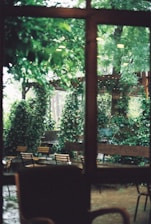 An outdoor seating space nestled in nature, with wooden furniture and lush greenery offering a tranquil getaway.