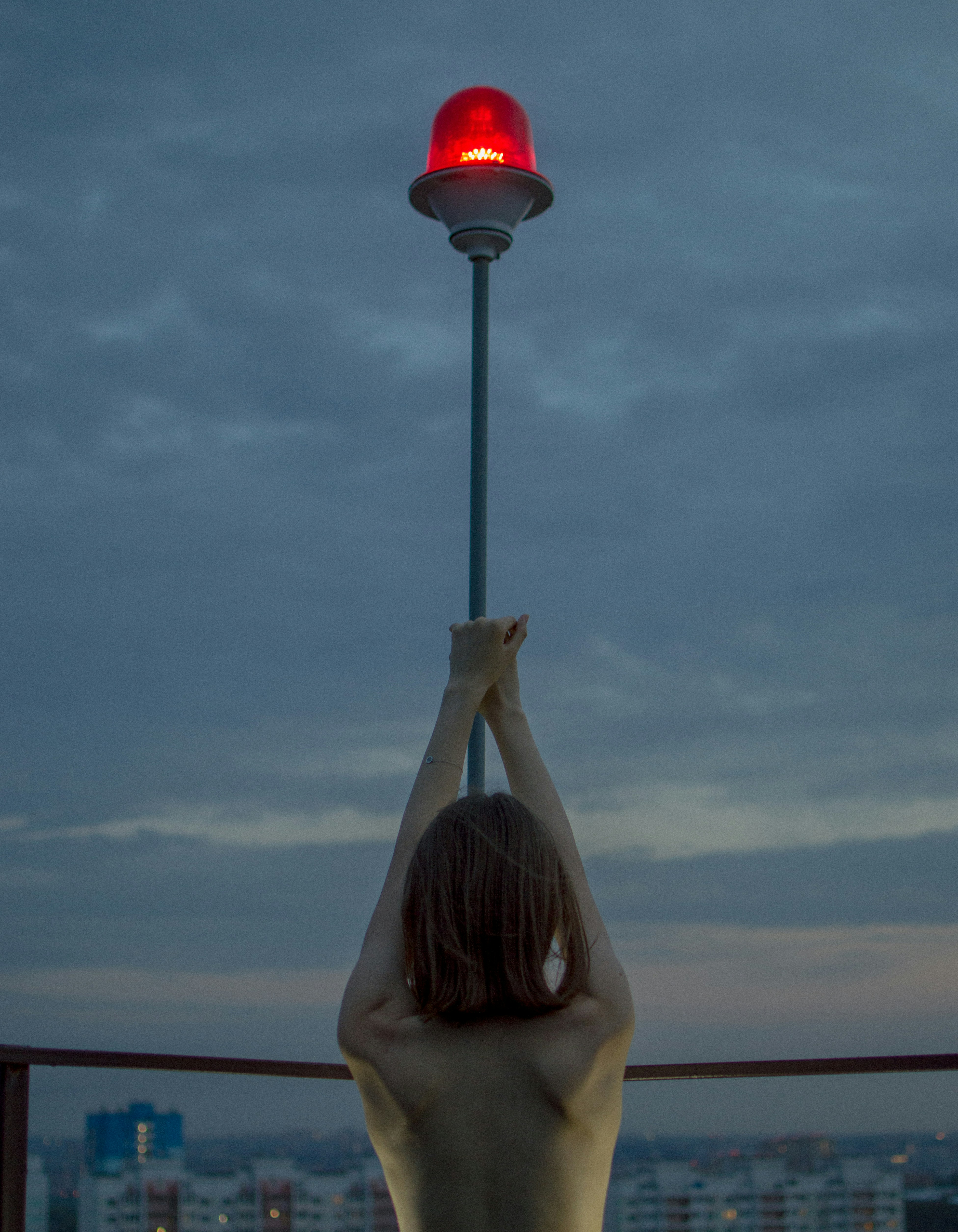 a woman standing on a balcony holding up a red light