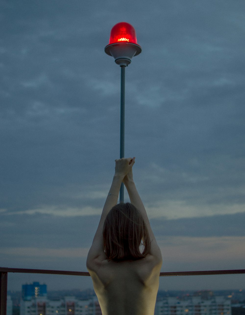 a woman standing on a balcony holding up a red light