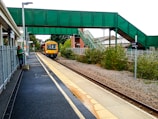 Professional driver greeting a smiling passenger at Coventry station.