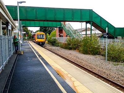 Driver helping a passenger with luggage beside a minibus at Coventry station.