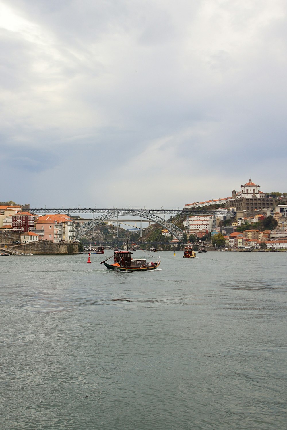 a boat traveling down a river next to a bridge