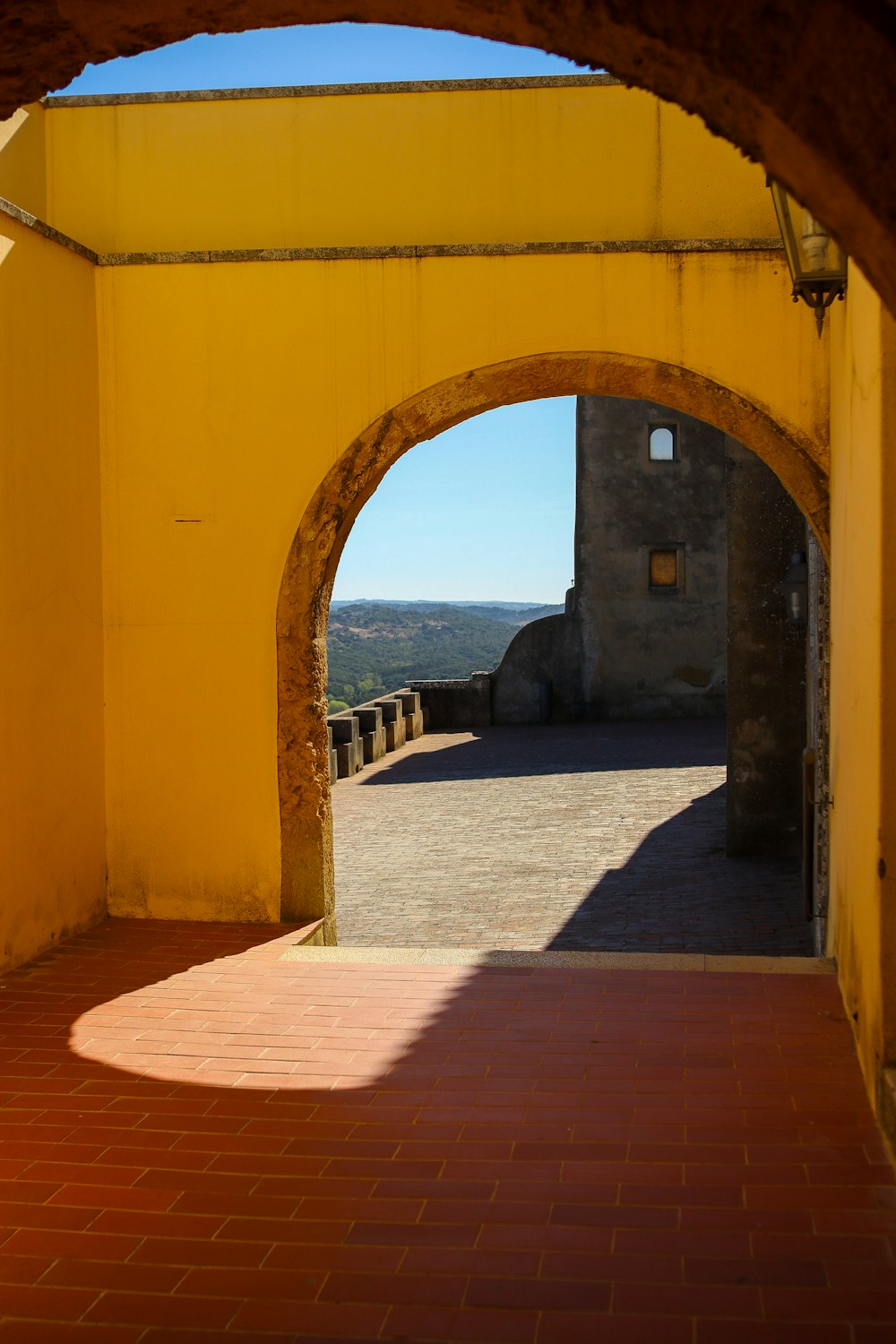 a yellow building with a brick walkway leading to it