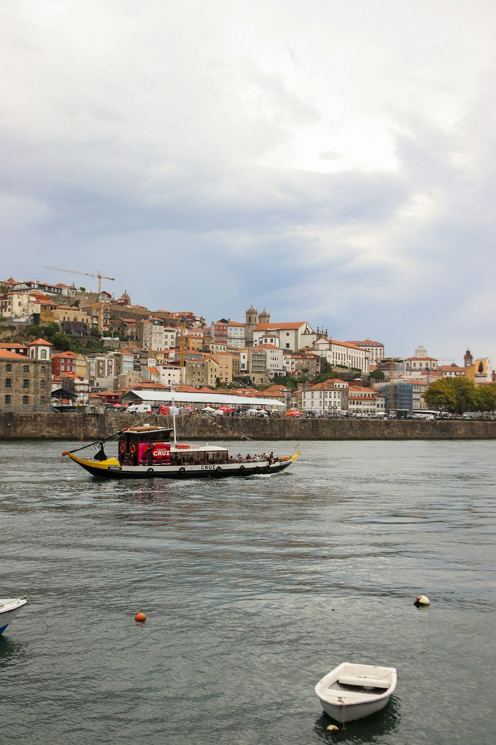 a boat floating on top of a lake next to a city