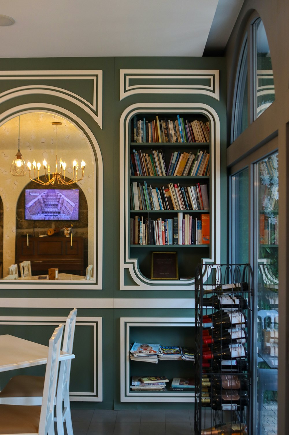 a room with a table, chairs and a book shelf