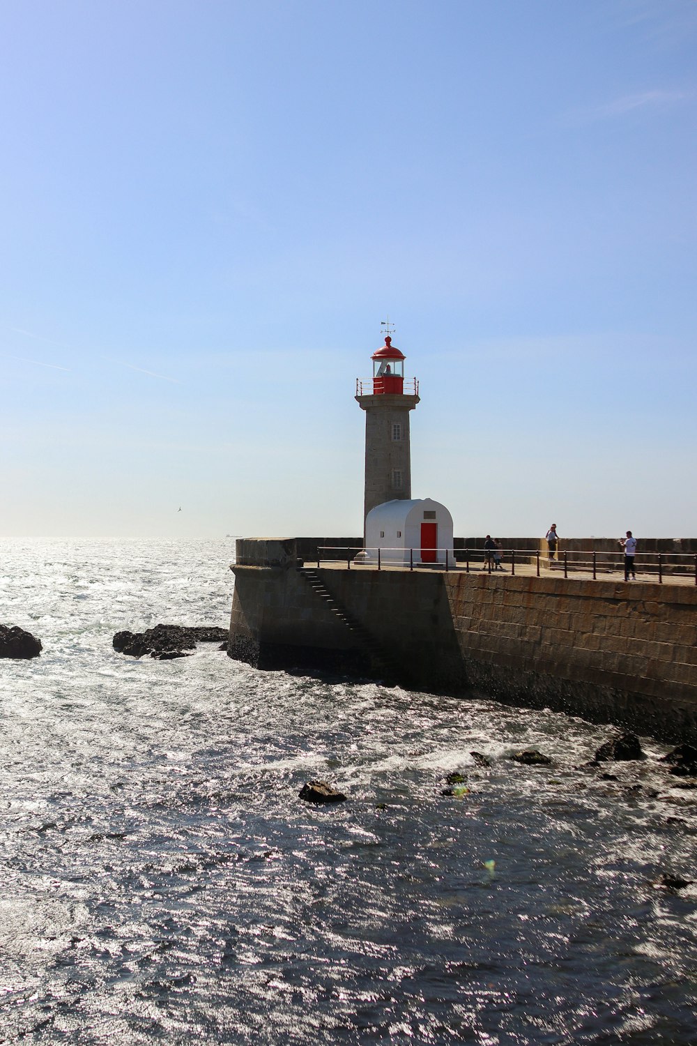 a light house sitting on top of a pier next to the ocean