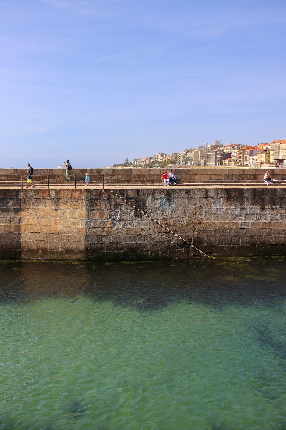 a group of people standing on a bridge over a body of water