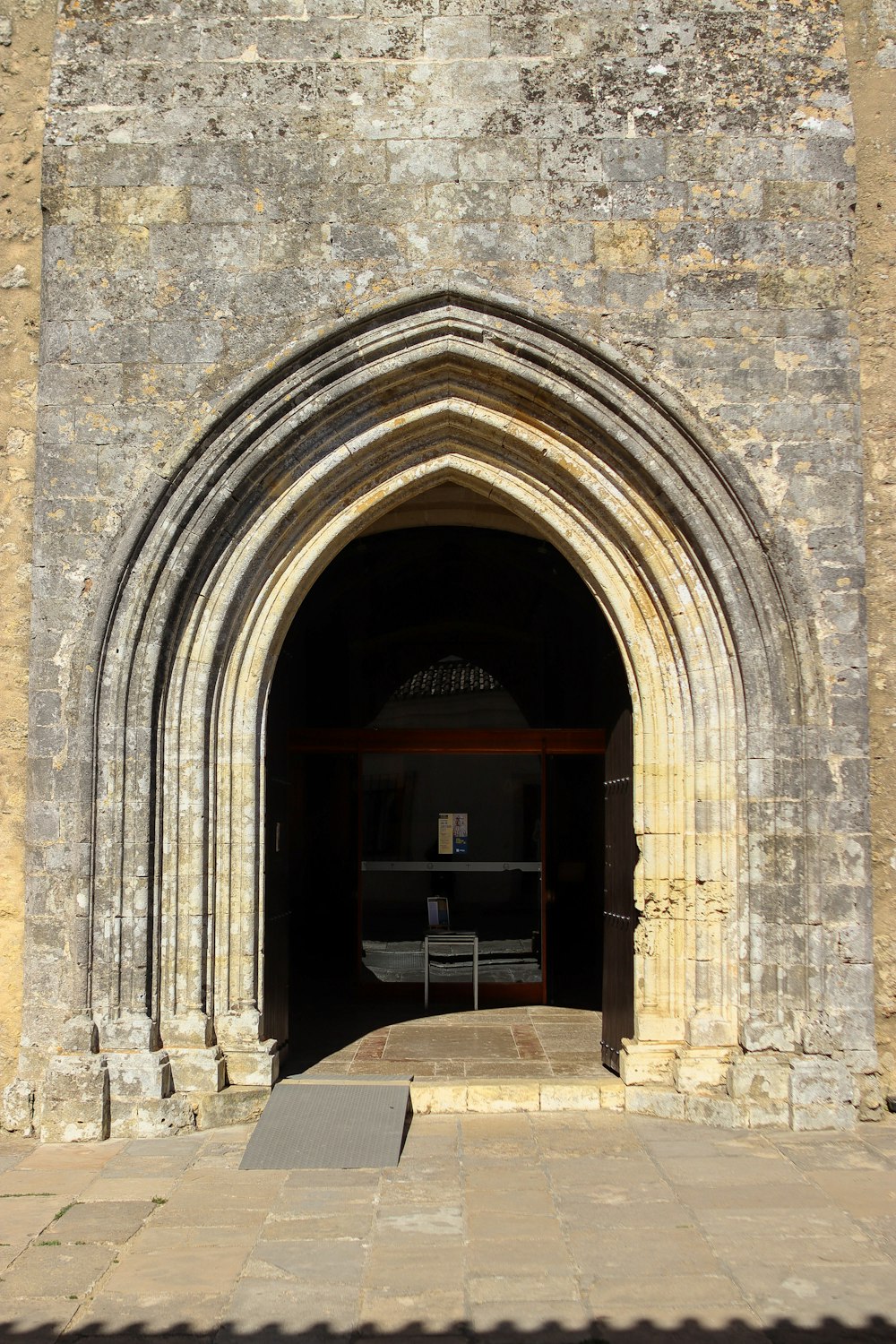 a stone arch with a bench in the middle of it