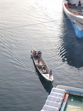 A marine vessel being carefully relocated across calm waters.