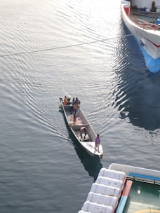 A marine vessel being carefully relocated across calm waters.