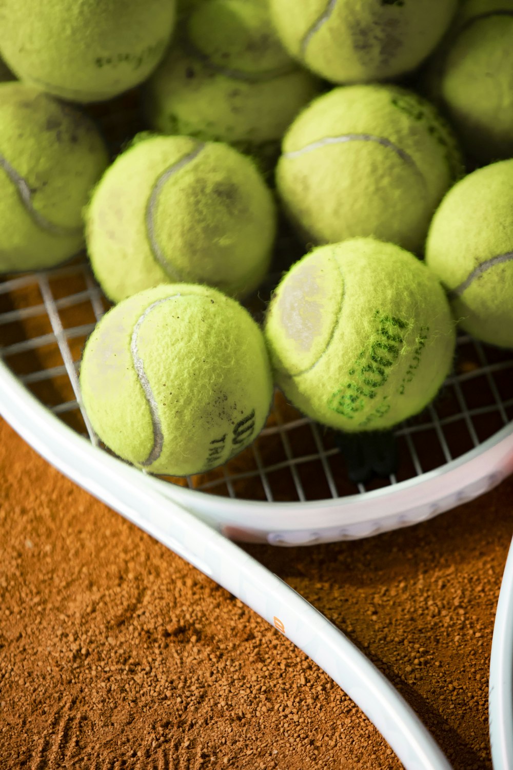 a bunch of tennis balls sitting on a racket