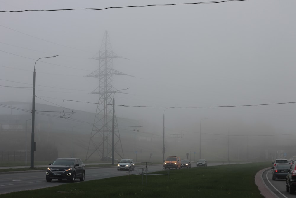 a group of cars driving down a road on a foggy day