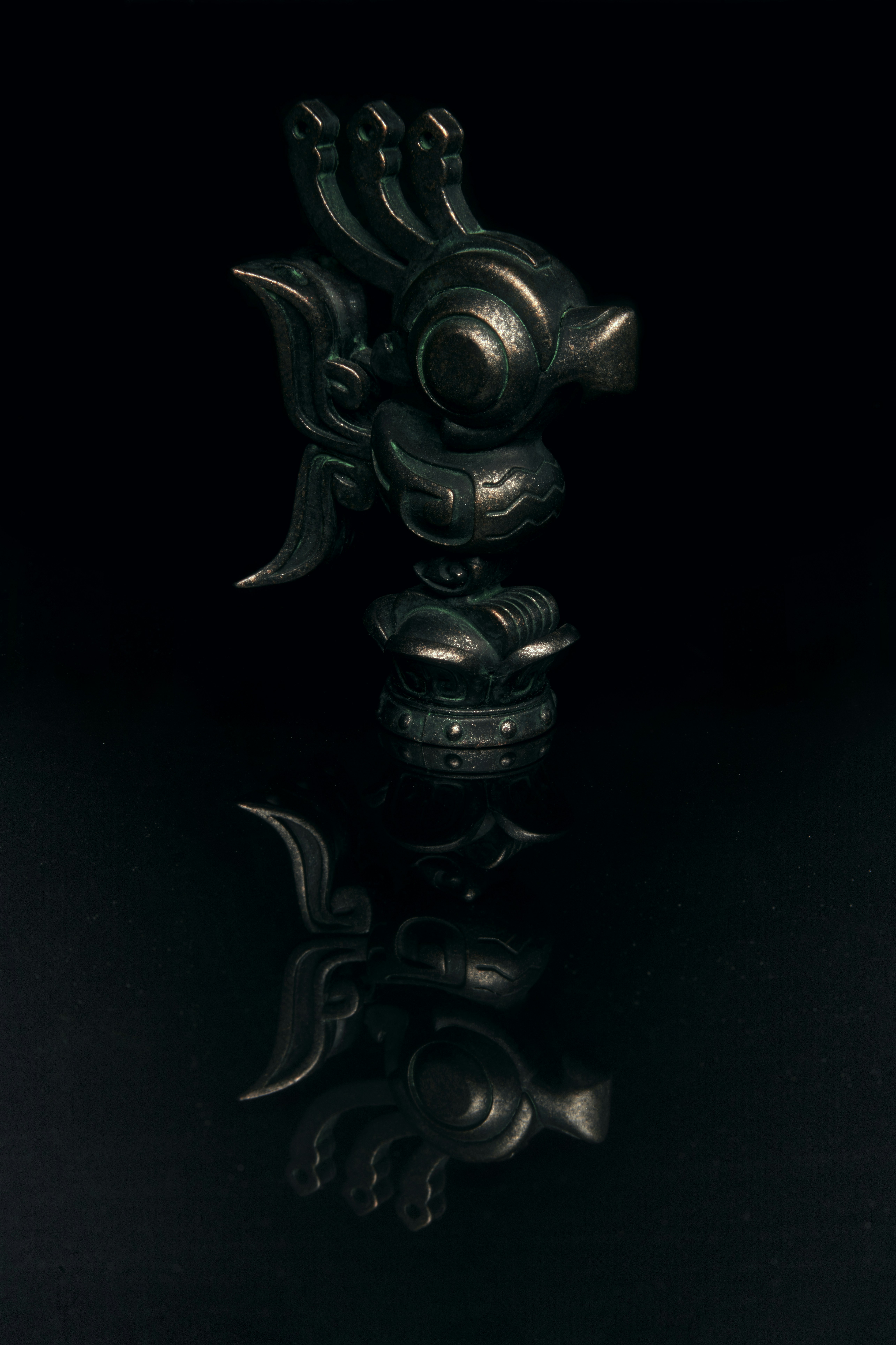 a black object with a reflection on a black surface