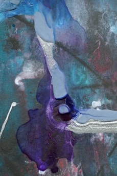 An abstract painting with a mix of vivid colors and textures. The dominant color is a deep purple spread across the bottom and center, merging with patches of blue, cyan, and teal. Silver and white streaks create a dynamic contrast. There are hints of red around the edges, all set against a grey, textured background.