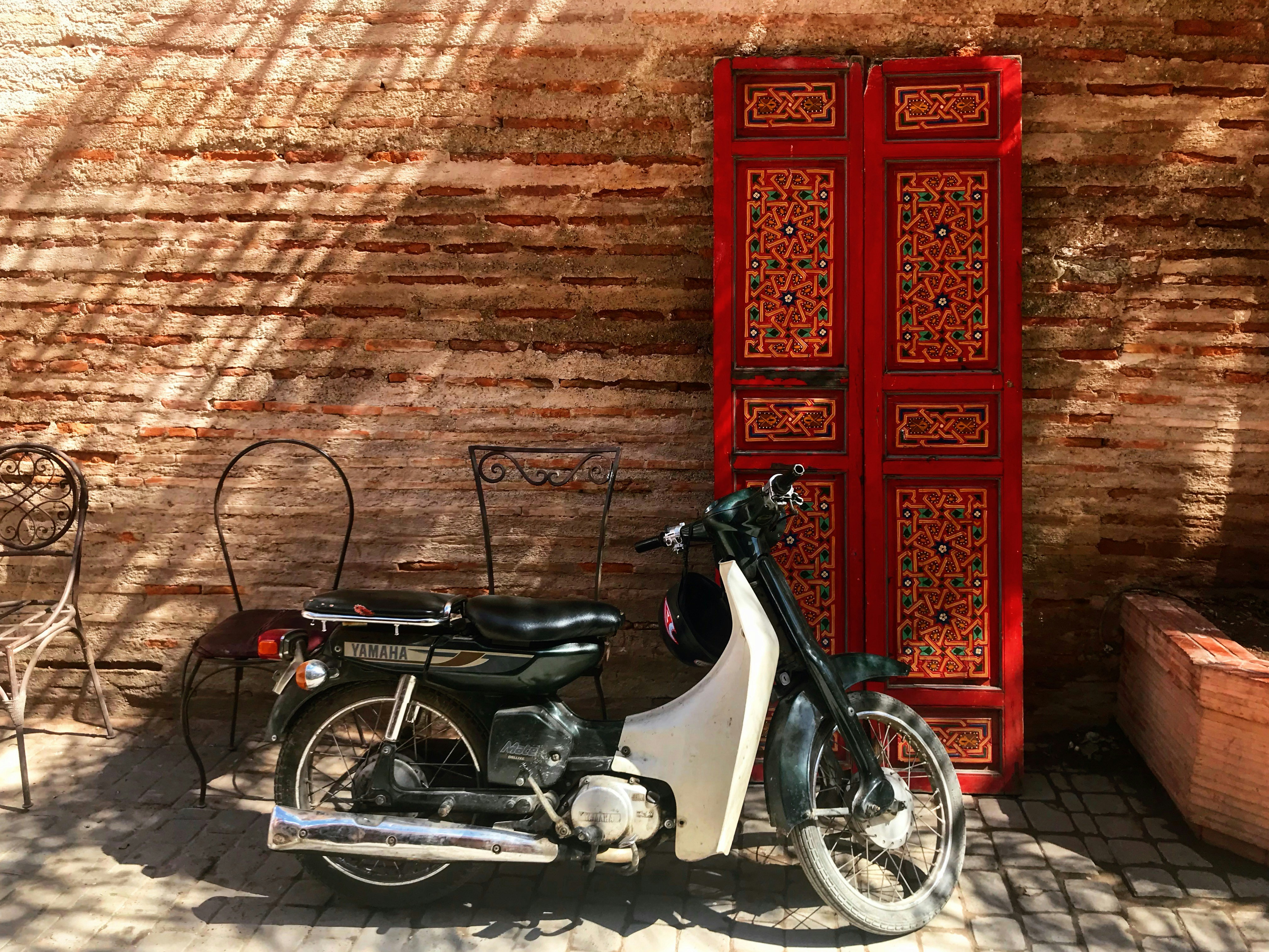 A motor scooter parked in front of a red door