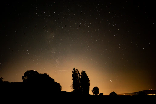A glowing Ten of Cups tarot card set against a soft, starry night sky.