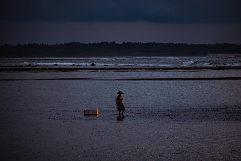 a person walking across a wet beach at night