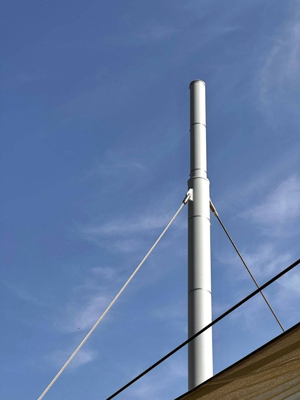 a tall white pole sitting next to a building