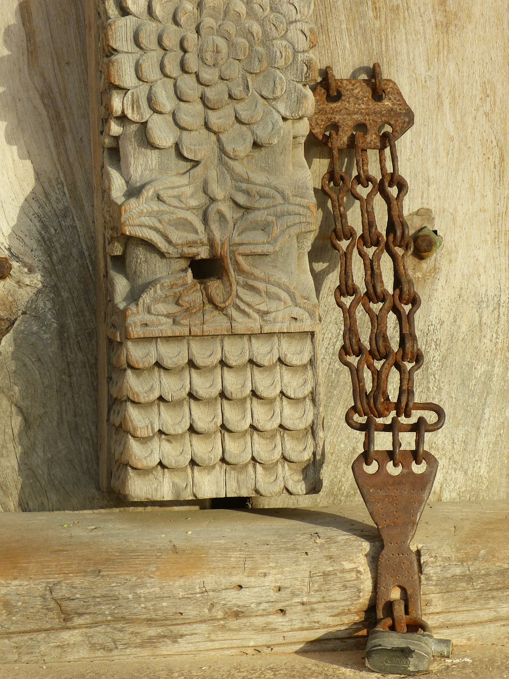 a decorative piece of wood with chains attached to it