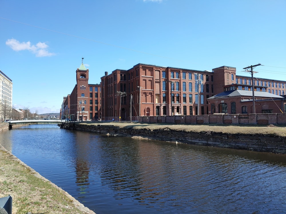 a large brick building next to a body of water