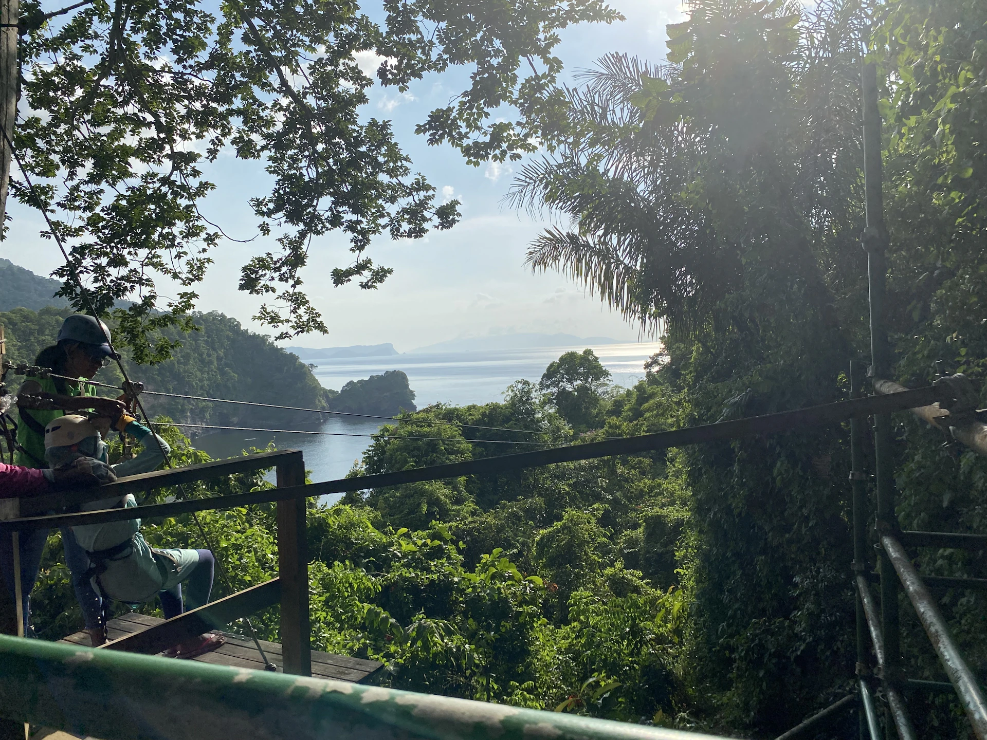 Adventurers zip-lining through the canopy above Costa Rica's coastal rainforest, capturing the thrill of outdoor exploration.