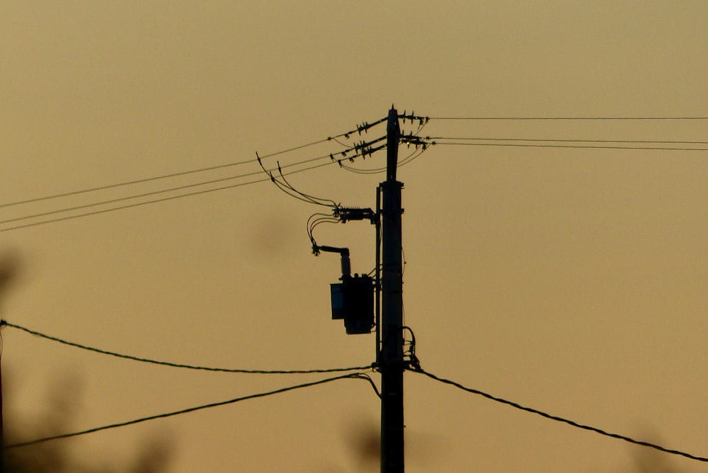 a telephone pole with power lines and telephone wires