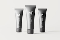 Three black tubes of different sizes are arranged on a plain background. Each tube is labeled with the letters 'MF' and the words 'black tube mockups' in white text. The tubes are cylindrical with flat caps and appear to be standing upright.