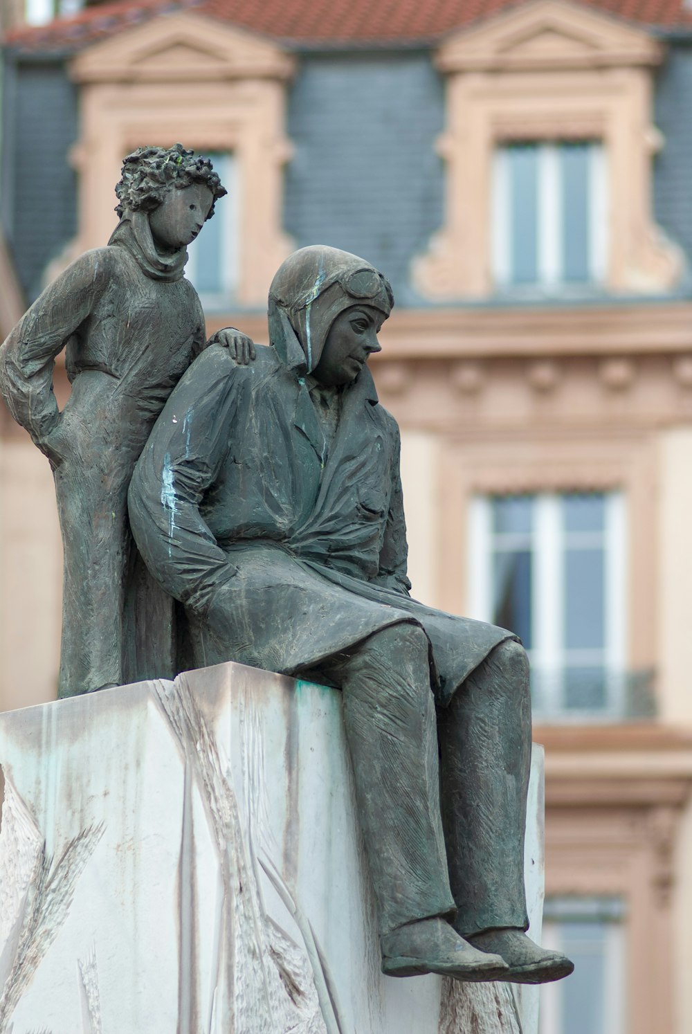 a statue of a man sitting next to another man