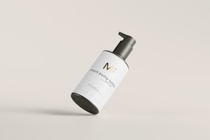 A sleek, minimalist black and gold beauty tool displayed on a white background.