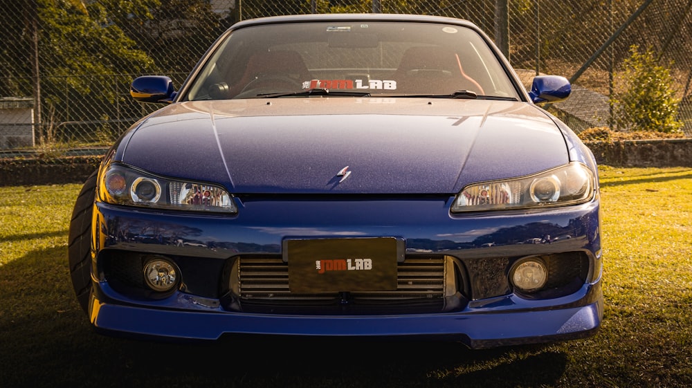 a blue sports car parked in the grass