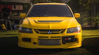 a yellow car is parked in the grass