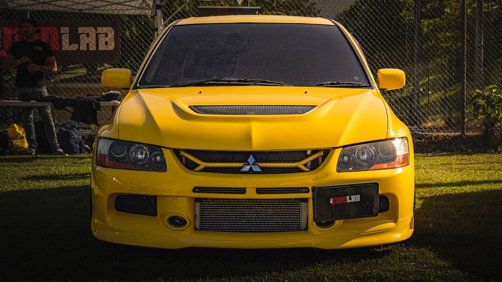 a yellow car is parked in the grass