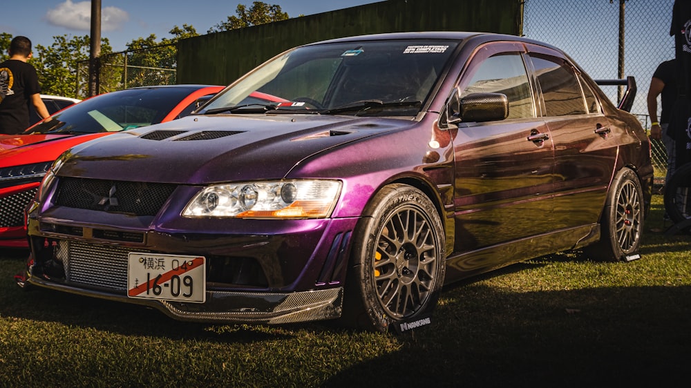 a purple car parked next to a red car