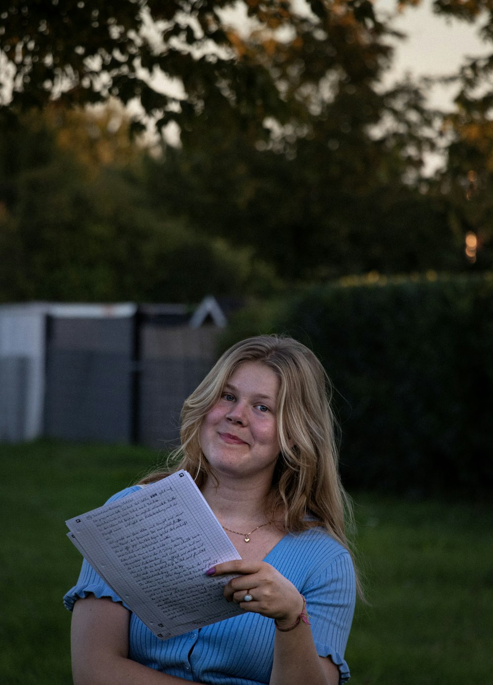 a woman in a blue shirt is holding a book