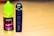 A bottle of fruit-flavored vape juice with a bright green cap and colorful label sits next to a sleek black vape device on a wooden surface.