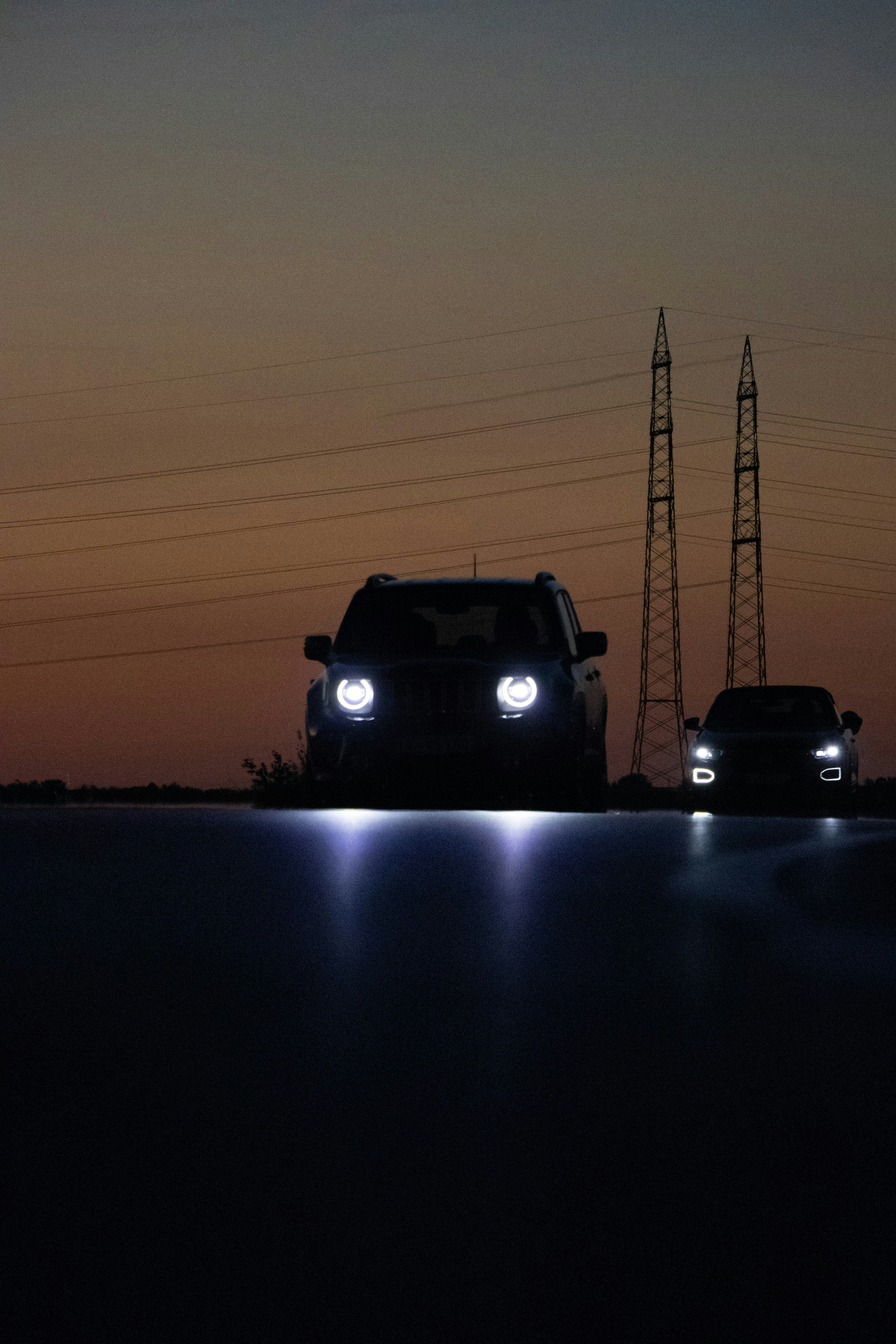 A couple of cars driving down a road at night photo – Free Car Image on ...
