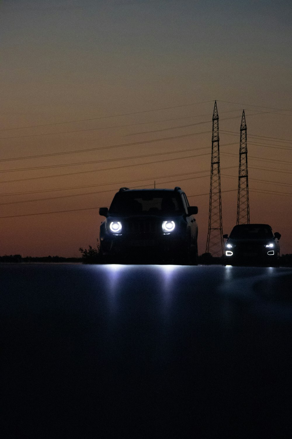 a couple of cars driving down a road at night