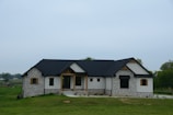 a stone house with a black roof and windows